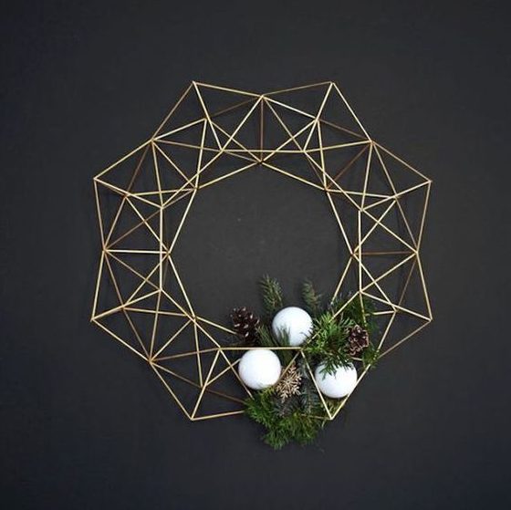 a modern himmeli Christmas wreath shaped as a crown, with white ornaments, greenery and pinecones is a lovely and chic idea