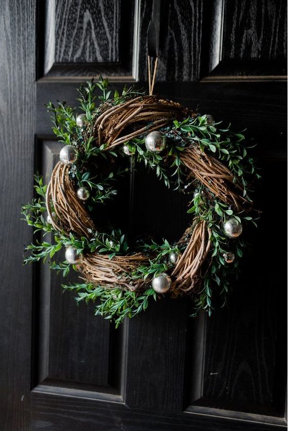 a modern rustic Christmas wreath with evergreens and silver ornaments is a gorgeous decoration to rock