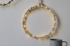 a pretty holiday wreath of lights and white berries is a delicate and cool decoration for the holidays