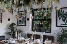 a pretty overhead installation with greenery, white blooms and green and gold ornaments is lovely