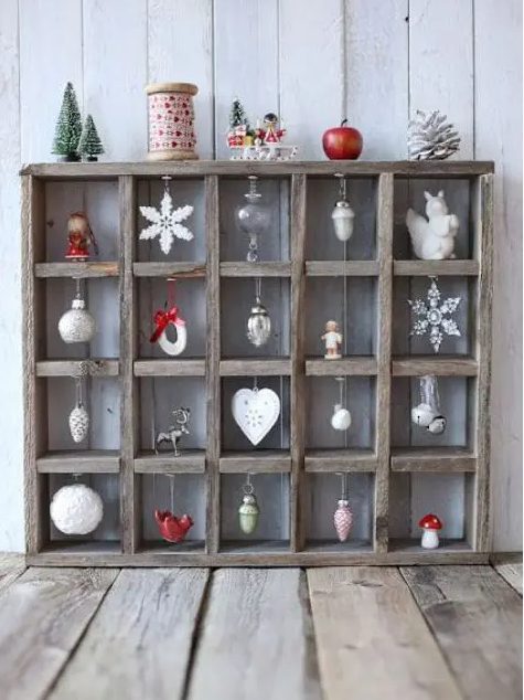 a pretty rustic Christmas ornament stand of wood, with various Scandi-themed ornaments and some additional decor on top