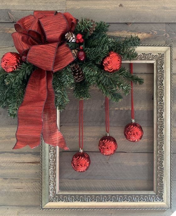 a sophisticated frame Christmas wreath with evergreens, pinecones and berries, an oversized red ribbon bow and red ornaments