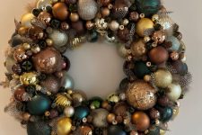 a super bright and chic Christmas wreath made completely of ornaments in gold, brown, teal and dark green looks amazing