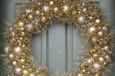 a super glam and shiny christmas wreath composed of silver and gold glitter ornaments and matching tinsel will shine bright