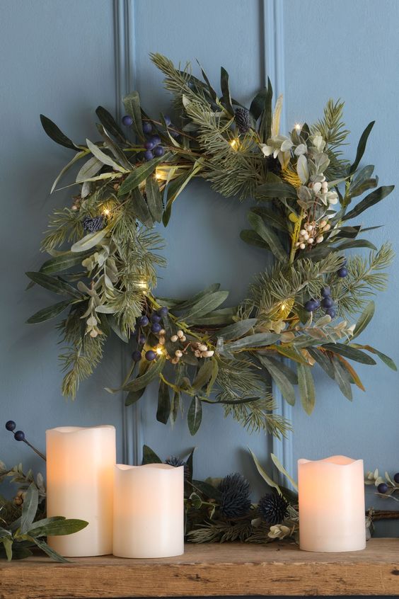 a textural greenery Christmas wreath with white and blueberries and lights is cool for natural decor