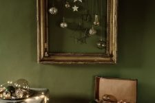 a vintage picture frame with ornaments hanging is a beautiful decor idea for the holidays