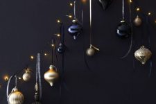 a wall-mounted decoration of lights and black and gold ornaments hanging on them is a cool idea