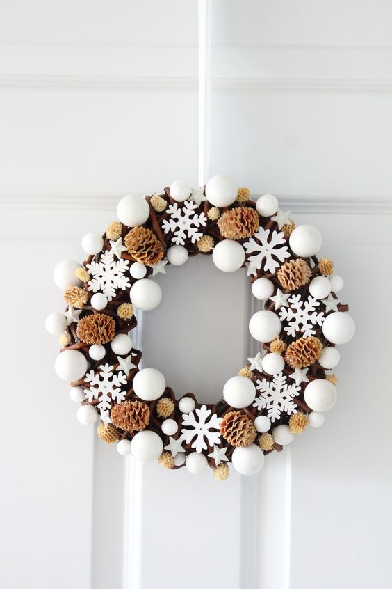 a whimsical Christmas wreath of white ornaments, white snowflakes and stars and pinecones is amazing