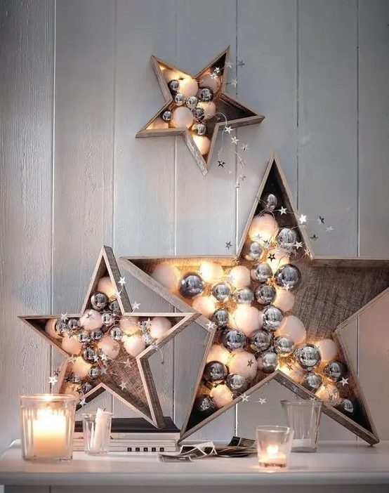 plywood stars filled with white and silver ornaments and lights are cute and chic festive decor options