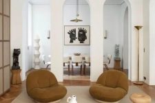 06 a modern earthy living room with a catchy two-piece coffee table, rust chairs, a wooden stool and some decor