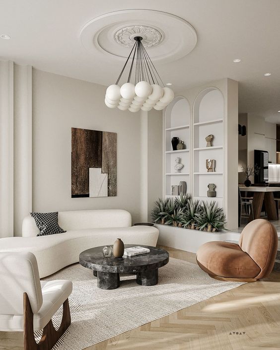 a neutral living room with a creamy curved sofa, a rust chair, a white one and a black coffee table plus potted plants