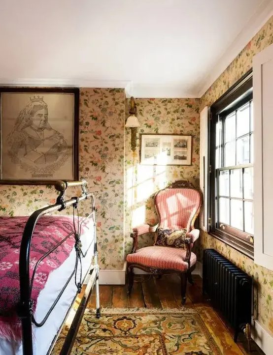 a cozy vintage-inspired bedroom with a floral wallpaper wall, polka dot bedding, vintage-inspired furniture and a blush lamp