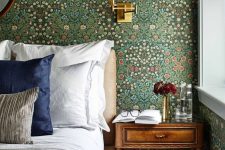 a bedroom with a moody floral wallpaper