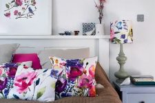 24 a modern neutral bedroom spruced up with bold floral pillows, a blanket, an artwork and a lamp with a floral lampshade