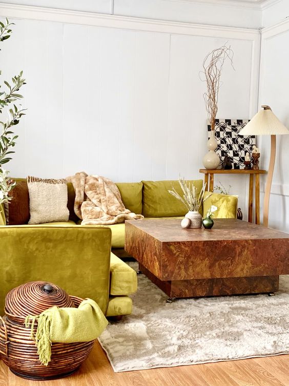 a unique living room with a chartreuse sofa, a stone coffee table, some decor and lamps plus a basket with a lid
