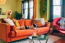 33 a colorful living room with chartreuse walls, an orange sofa and a pink chair, some plants and pendant lamps
