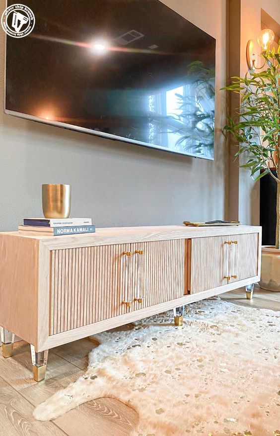 a neutral TV console with fluted doors and clear legs and handles is a lovely idea for a modern space
