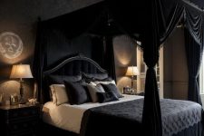 41 a modern Goth bedroom with black walls, a black canopy bed with real drapes, black and white bedding and black nightstands