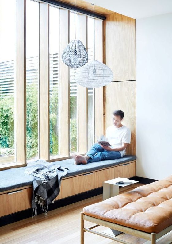 a low upholstered window sill that doubles as a daybed and a storage unit
