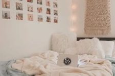 a boho teen bedroom with a black bed with white and blue bedding, a macrame hanging, lights and a grid gallery wall