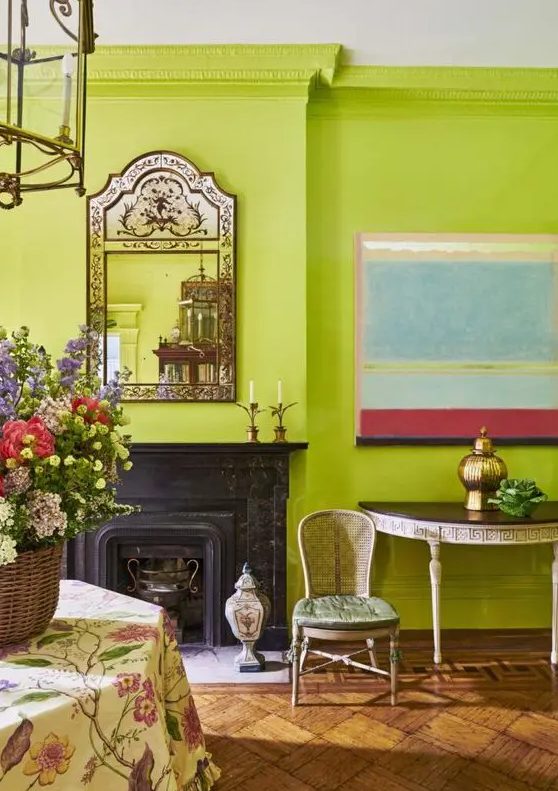 a bold chartreuse living room with a black fireplace, vintage furniture, mirror, a pendant lamp and some blooms and decor