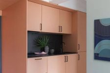 a built-in Peach Fuzz kitchen with a black countertop, backsplash and fixtures is a cool space to spend time in