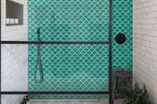 a catchy contemporary bathroom with neutral patterned tiles and a gorgeous emerald fishscale tile wall in the shower