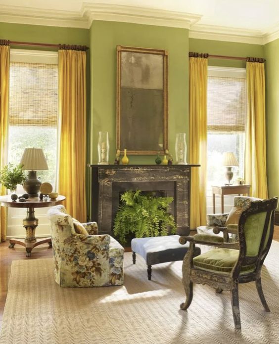 a chartreuse living room with a black fireplace, green and printed floral chairs, an ottoman and elegant tables with lamps