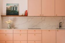a contemporary Peach Fuzz kitchen with a white stone backsplash and countertops, a shelf and some decor