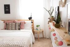 a cool boho teen bedroom with an open shelf that features decor and greenery, a wooden bed, a bench and a rattan basket