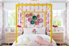a fun teen girl room with bright pineapple wallpaper, a yellow canopy bed, a bold gallery wall and pink rugs