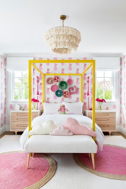 a fun teen girl room with bright pineapple wallpaper, a yellow canopy bed, a bold gallery wall and pink rugs