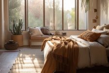a light-filled earthy boho bedroom with a bed with rust bedding and a large boho rug, pillows and potted plants