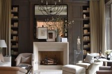 a lovely living room with taupe walls, built-in shelves, a fireplace, neutral seating furniture and a sphere lamp
