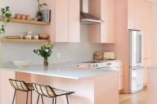 a lovely peachy pink flat panel kitchen with white granite countertops, tall woven stools and open shelving is amazing