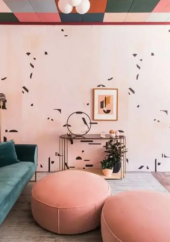 a lovely pink living room with a colorful ceiling, printed walls, a green sofa, Peach Fuzz ottomans and potted plants