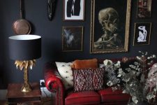 a modern Goth living room with soot walls, a red sofa and colorful pillows, a gallery wall, a living edge table and dried blooms