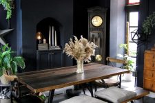 a modern Gothic dining space with a built-in cabinet, a stained dining set, potted plants, a grandfather’s clock