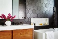 a modern bathroom with soot hexagon tiles, neutral tiles, a rich-stained vanity, a tub and a mirror cabinet