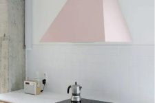 a modern neutral kitchen with white countertops, a white square tile backsplash and a pink geometric hood that is wow