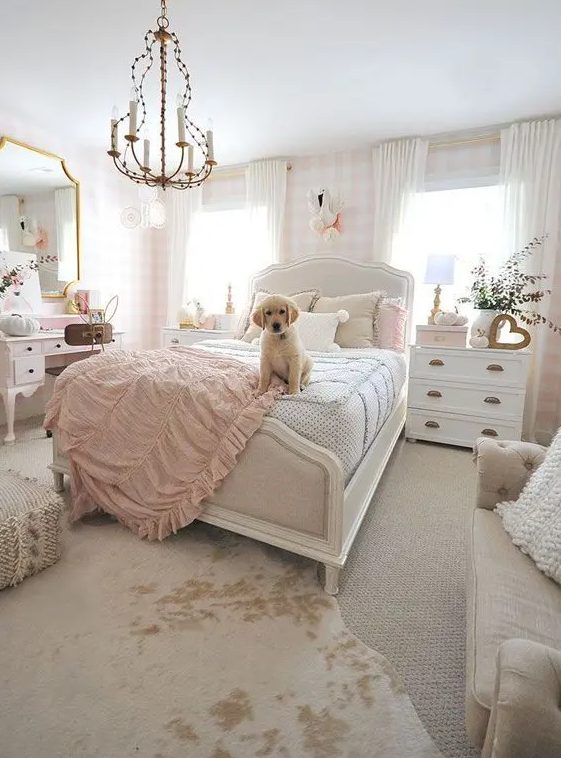 a neutral and lovely teen girl's bedroom with plaid wallpaper, a white bed with neutral bedding, white dressers, a blush vanity and a large mirror, a sofa