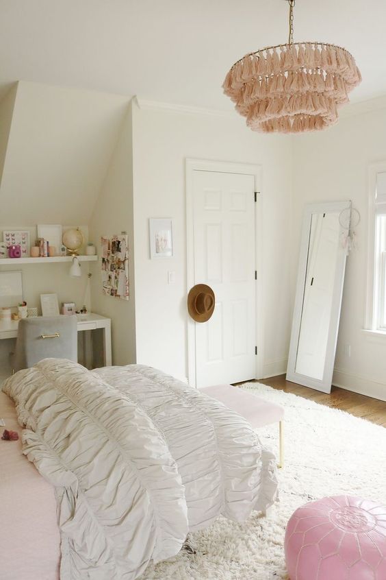 a neutral modern teen girl room with a vanity and a chair in the corner, some shelves, a bed and a blush bench, a pink pouf