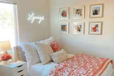 a neutral modern teen room with white furniture, bright textiles, a gallery wall and a neon light over the bed