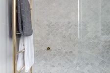 a neutral shower space with grey marble fish scale tiles, a gold radiator is a cool and stylish modern space