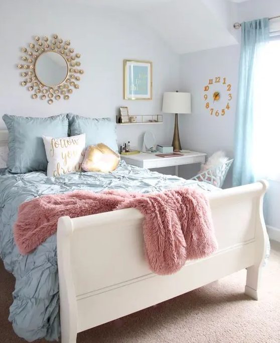 a pastel bedroom with a white bed and pastel bedding, blue curtains, a white desk as a nightstand, a white chair, a clock, a mirror and a table lamp