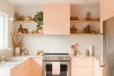 a peachy pink kitchen with neutral stone countertops, open shelves and some lovely decor is a very cozy space
