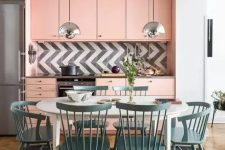 a peachy pink mid-century modern kitchen with a graphic tile backsplash and a dining zone in blue right here