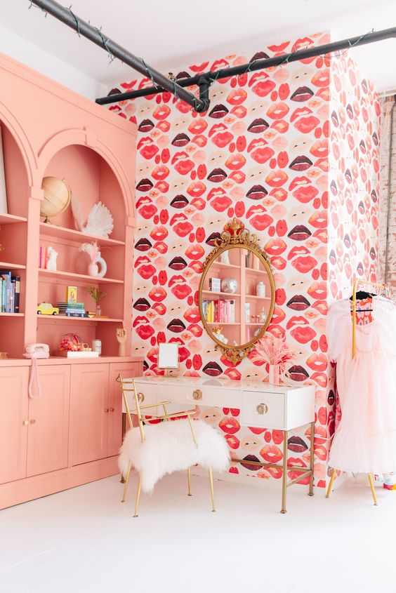 A pretty and bright space with Peach Fuzz bookcases built in, a kiss accent wall, a white vanity and a glam mirror
