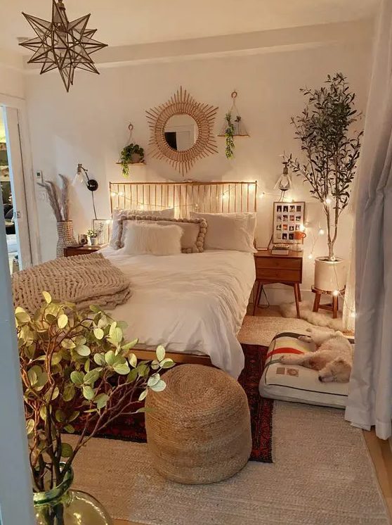 a pretty boho teen bedroom with a bed with a metal headboard, nightstands, potted plants, a dog bed, a jute pouf