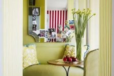 a refined chartreuse space with a matching loveseat and chair, a coffee table, a mirror and printed pillows is jaw-dropping
